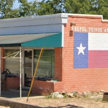 Brick building with Texas flag mural.