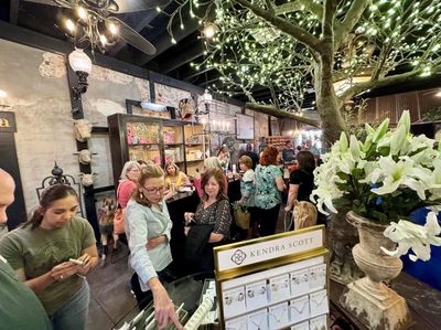 People shopping at a decorated indoor market with jewelry display.