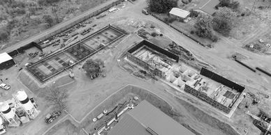 Aerial view of a construction site with building foundations and machinery.