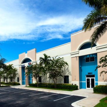 Commercial building with blue doors under a partly cloudy sky.