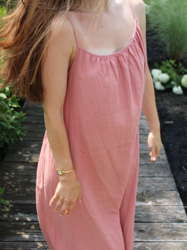 Woman in pink dress standing outdoors.