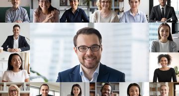 A diverse group of professionals in a virtual meeting, smiling and engaged.