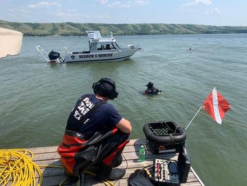 Supervisor overlooks a public safety diver in the water performing a mission