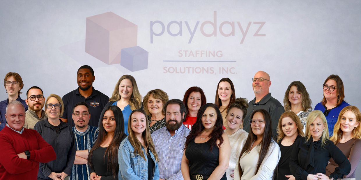 Group photo of Paydayz Staffing Solutions team in front of company logo.