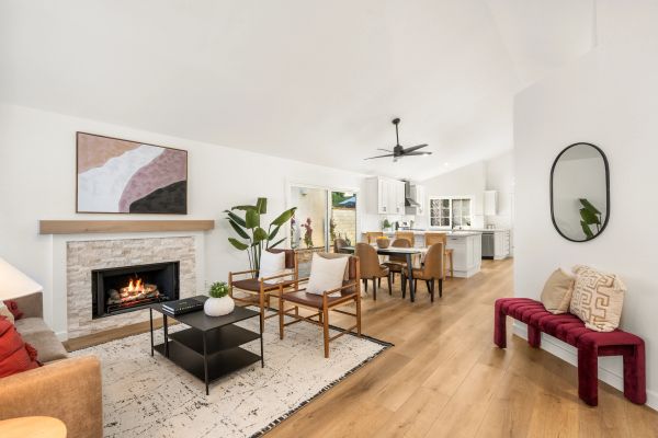 Bright, modern living space with fireplace and open kitchen.