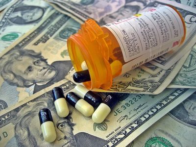 Medication bottles with pills on top of money