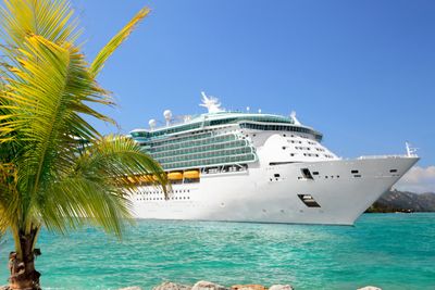 Cruse ship in the tropics with palm tree and blue water
