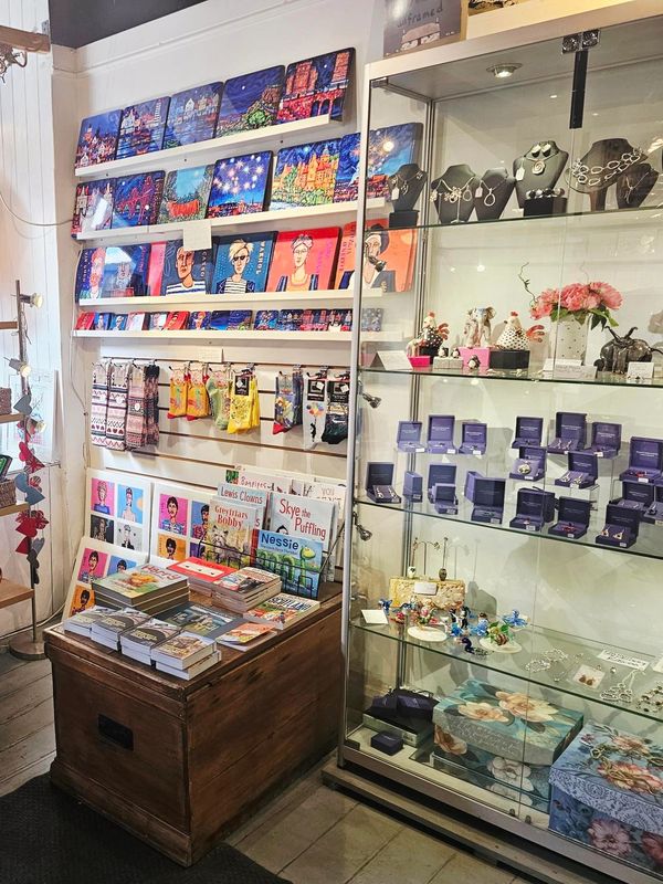 Cozy shop corner with art, books, jewelry, and accessories.