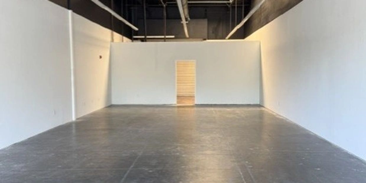 Empty room with white walls and concrete floor.