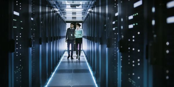 a man and woman walking in a server room 
