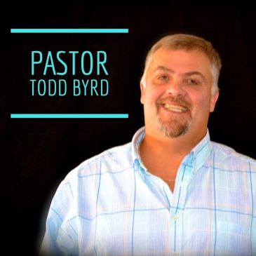 Pastor Todd Byrd smiling in a light blue checkered shirt.