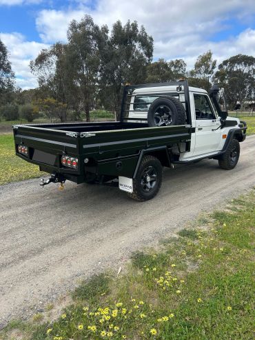 Black and white pickup truck on a rural road.