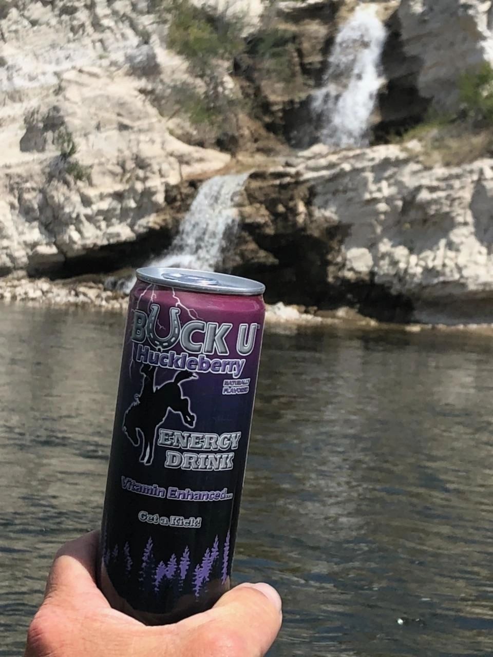 Buck U Energy Drink - Cans at River with Water Pouring