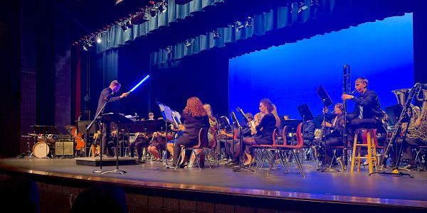 Conductor leads orchestra on stage.