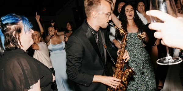 Man playing saxophone at a lively party.