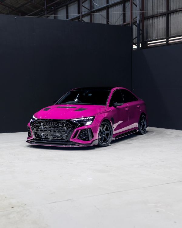 Bright purple sports sedan in a showroom.