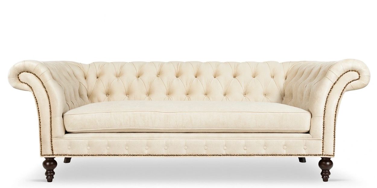 Elegant beige tufted sofa with rolled arms and dark wooden legs.