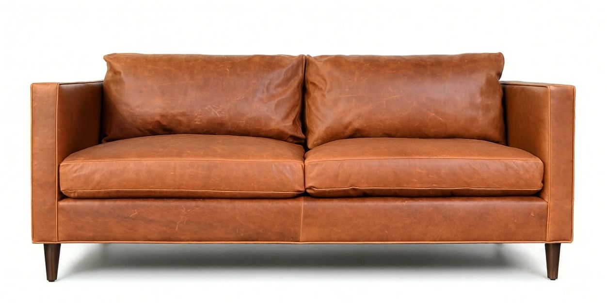 A modern brown leather sofa with clean lines and wooden legs.