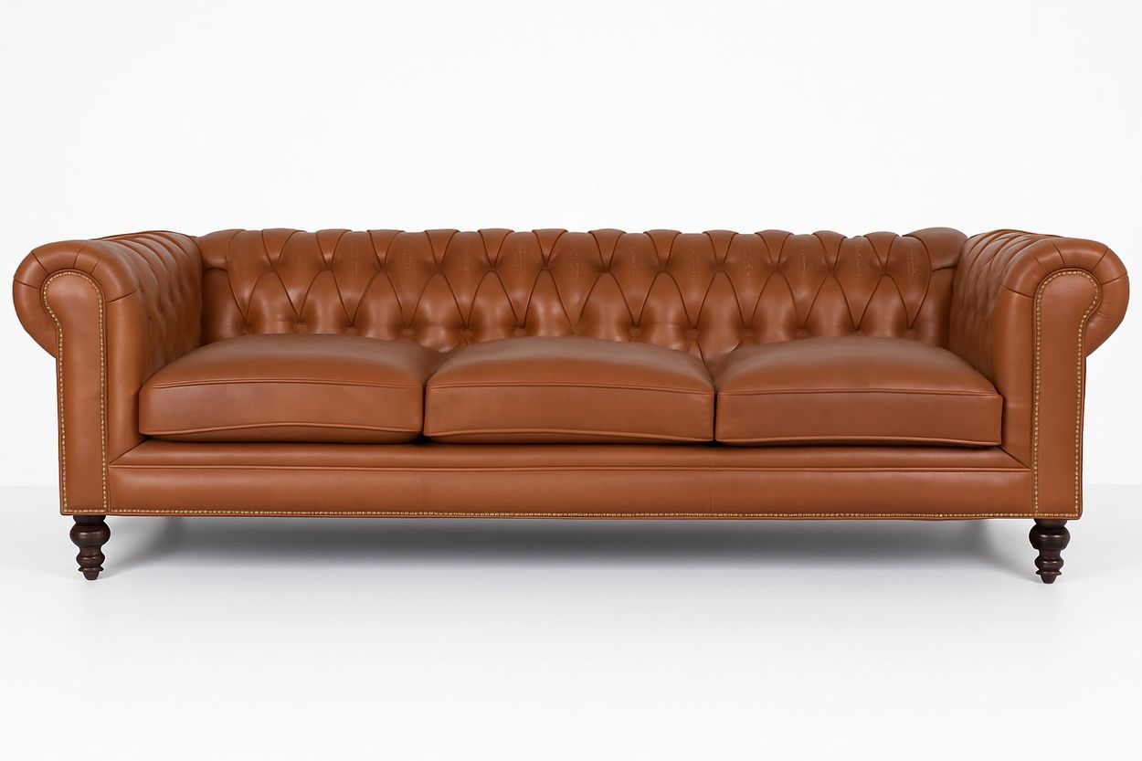 A classic brown leather Chesterfield sofa with tufted backrest and rolled arms.