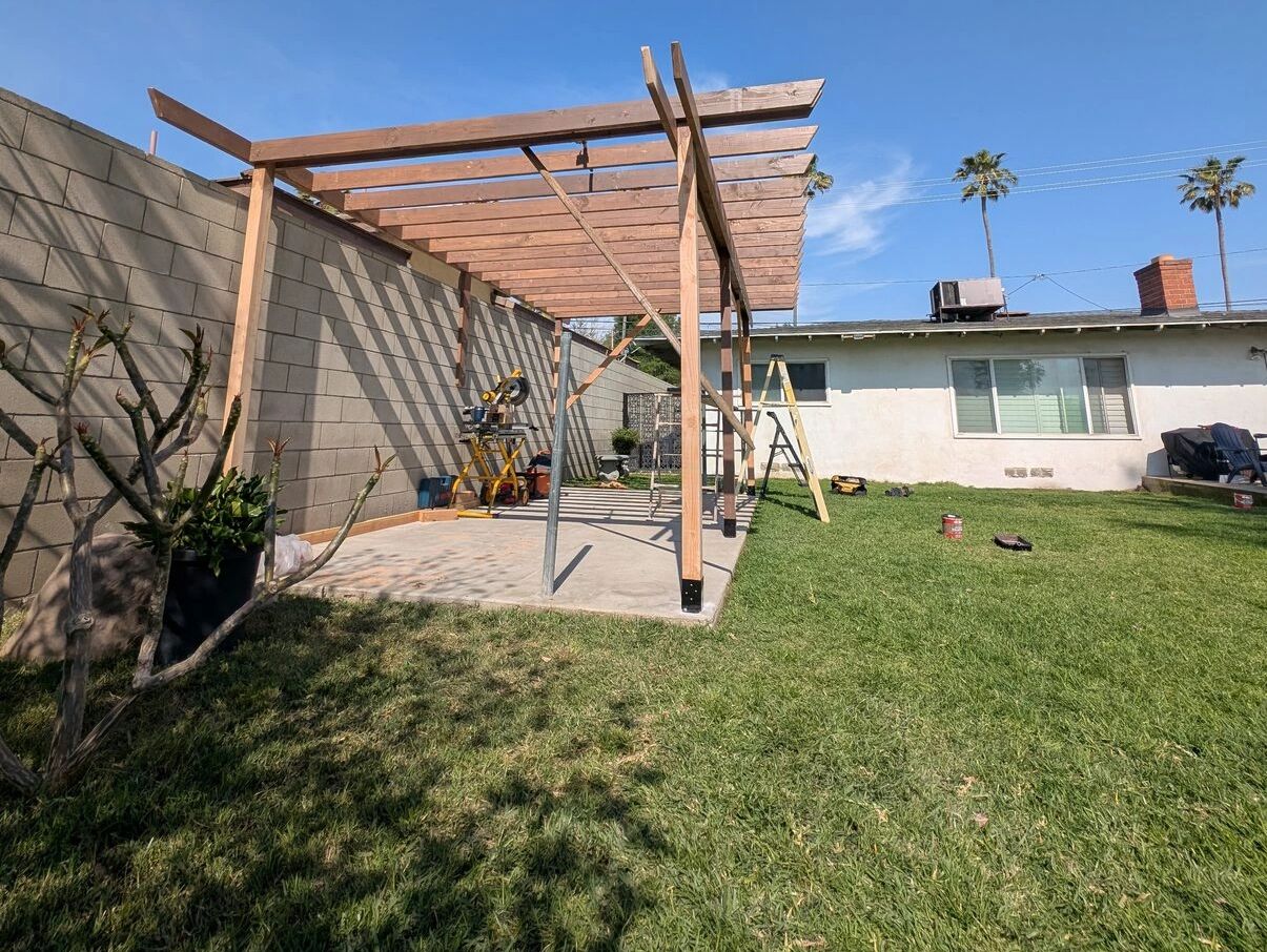 Pergola under construction over a backyard patio in Riverside