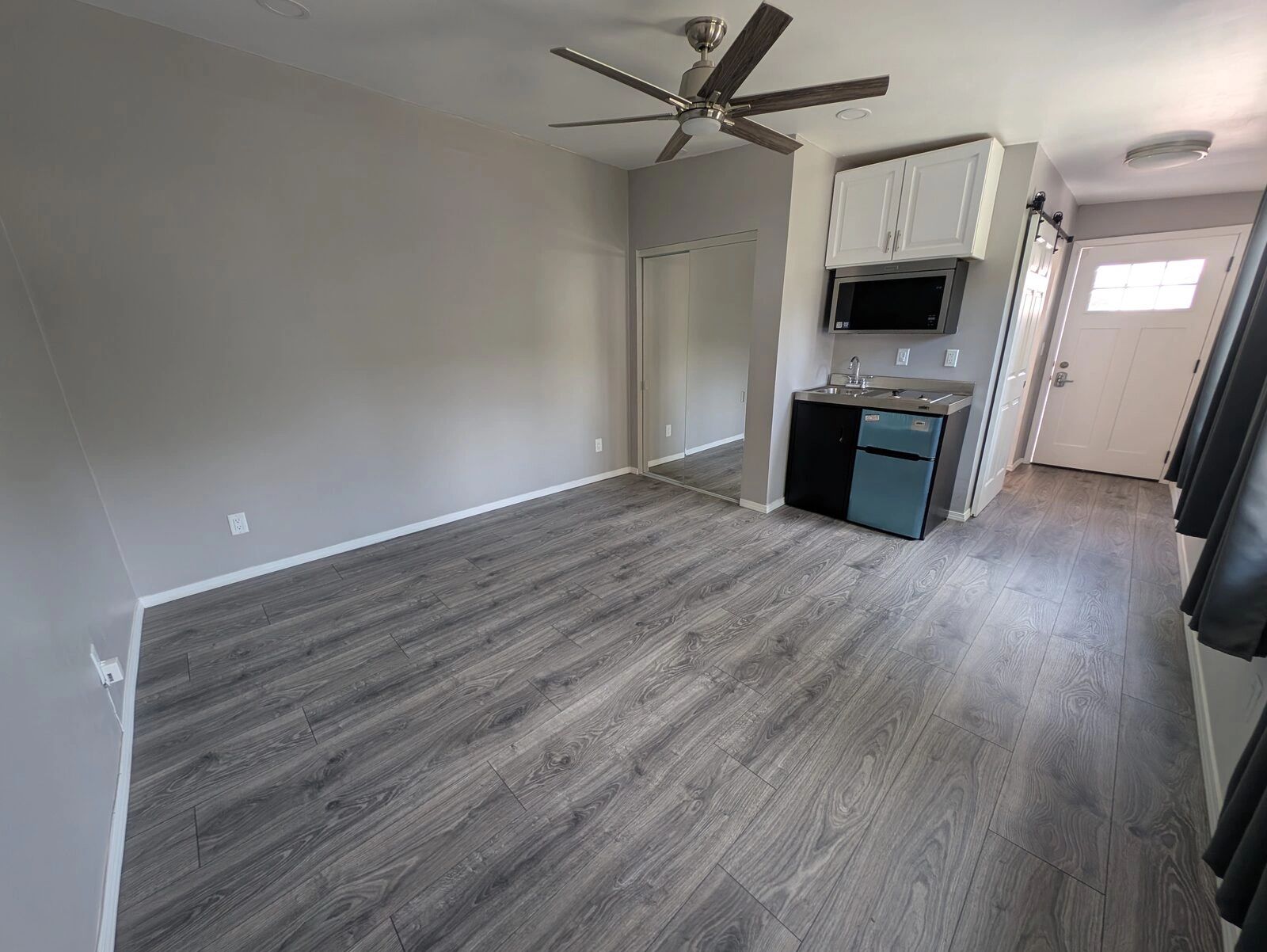 Studio unit with new plank flooring, ceiling fan and kitchenette in Colton