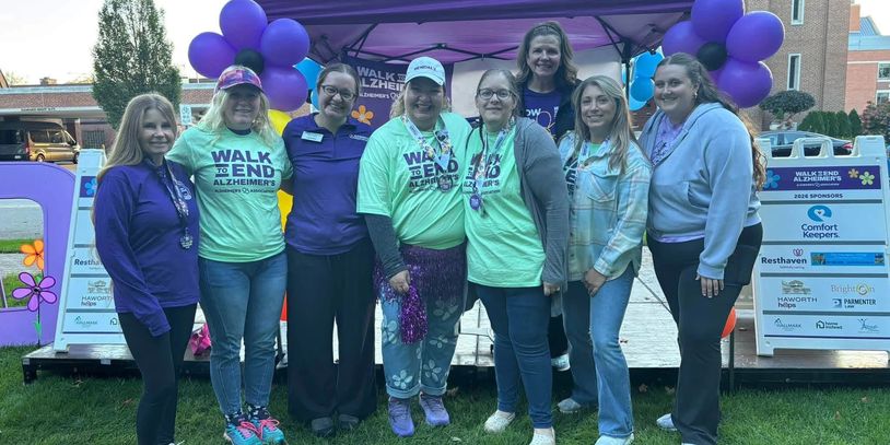 Group photo at Walk to End Alzheimer's event in front of balloon arch.