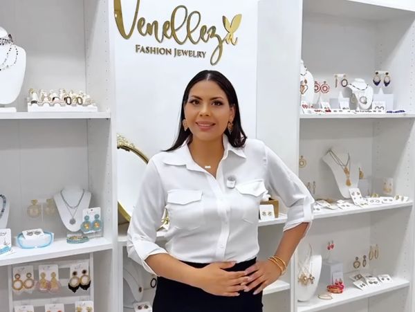 Woman standing in a jewelry store smiling.