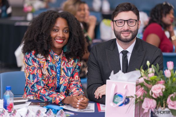 Two smiling people sitting together at a table.