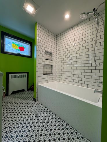 Modern bathroom with green walls and subway tiles.