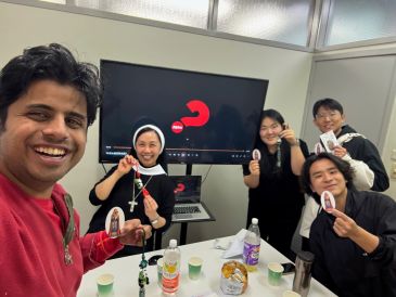 Group of people smiling and holding religious items.