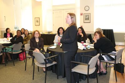 Janet Elie Faulkner standing to present at a professional meeting for attorneys seated at tables