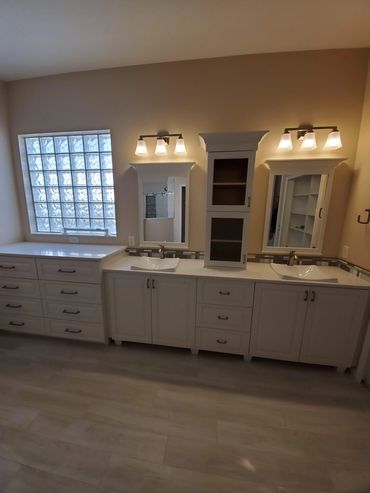 Modern bathroom vanity with dual sinks and bright lighting.