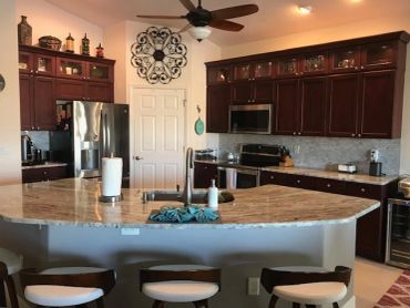 Modern kitchen with dark wood cabinets and granite countertops.