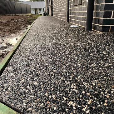 New textured concrete walkway alongside a brick building.