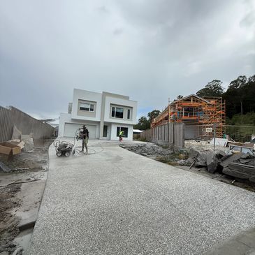Construction workers working on driveway of modern house.