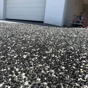 Close-up of textured asphalt ground near a garage door.