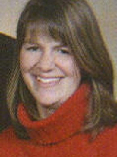 Woman smiling wearing a red sweater.