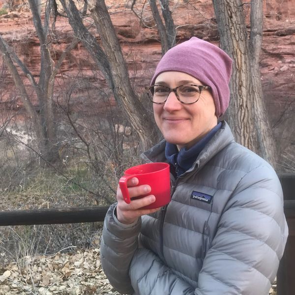 Woman standing outdoors drinking coffee in cold weather