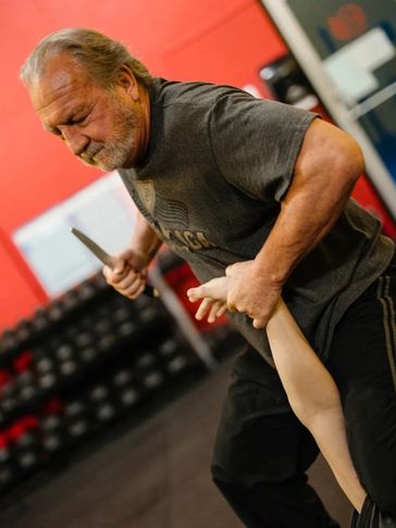 An older man practicing self-defense techniques.