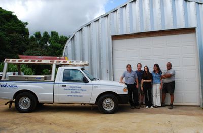 A team of five people standing beside a Raynor Kauai Overhead Door Company truck.