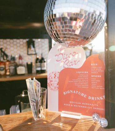Disco-themed bar menu with signature drinks and a disco ball.