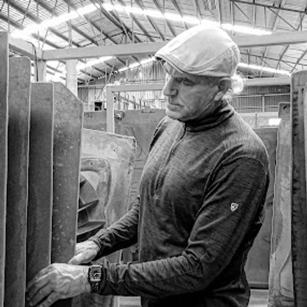 A man inspecting industrial equipment in a factory setting.