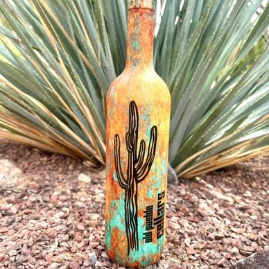 Rustic bottle with cactus design in desert landscape.