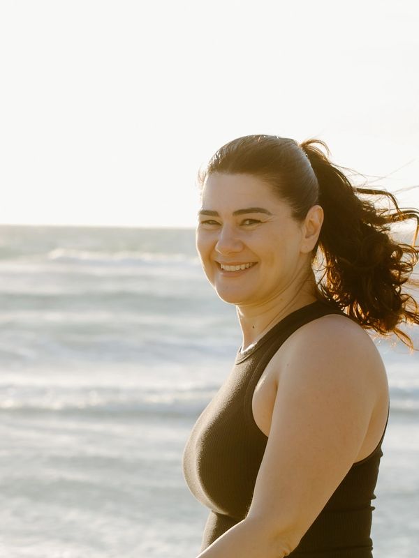 Smiling woman with ponytail at the beach.