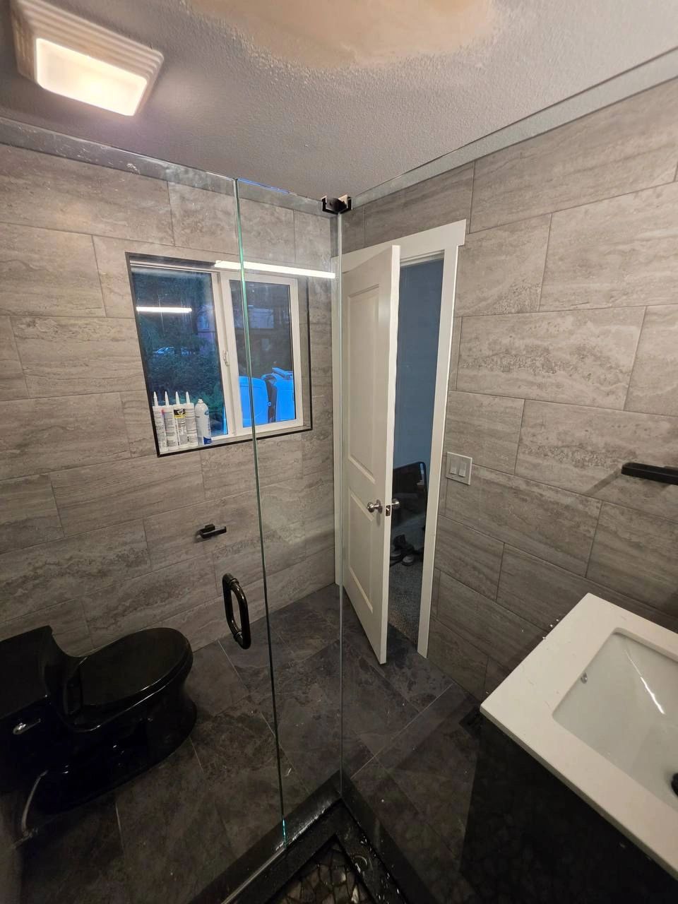 Tacoma bathroom remodel with gray tile shower and glass enclosure by CHR Construction Group