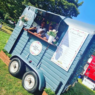 Outdoor mobile bar serving drinks in a green park.