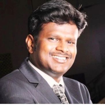 A smiling man in a suit and tie posing for a portrait.