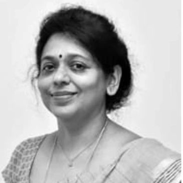 Black and white portrait of a smiling woman in traditional attire.