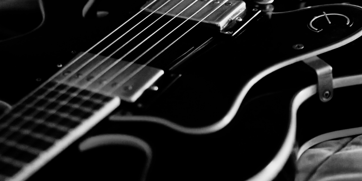 Black and white close-up of an electric guitar.