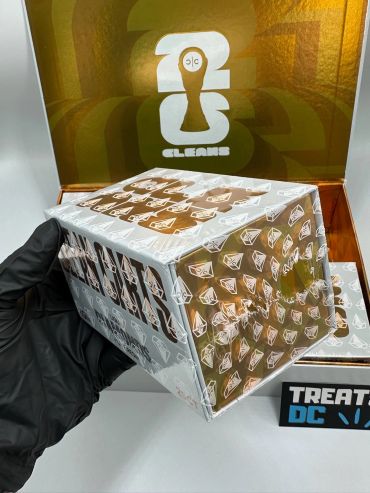 Gloved hand holding a shiny, wrapped box.